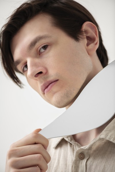 side view man posing with mirror piece